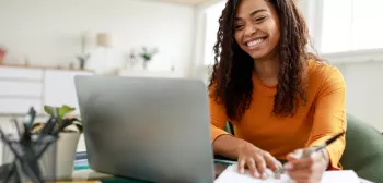 MBA student at laptop with notebook