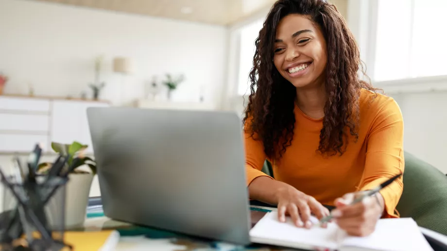 MBA student at laptop with notebook