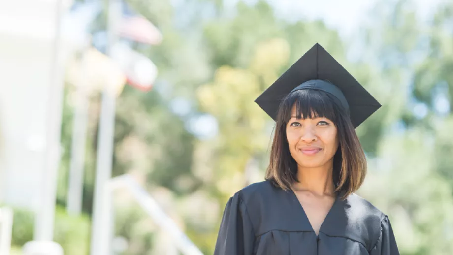 MBA graduate outside in front of trees